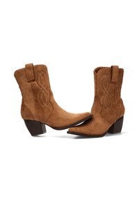 Botas de tobillo de ante marrón con punteras afiladas, patrones de costura decorativa y tacones cuadrados de 5 centímetros. Tiradores laterales para facilitar su uso.