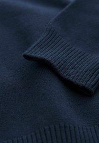 Maglione blu navy, texture a maglia, con polsini a coste e corpo in tessuto liscio, con finiture raffinate in tutto.