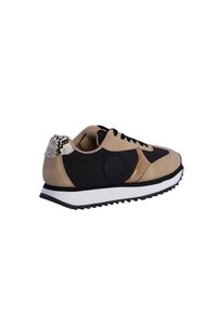 Zapatillas en ante beige y negro con un acento de piel de serpiente metálica texturizada. Presentan una suela blanca con dibujo en negro y un logo redondo en el lateral.