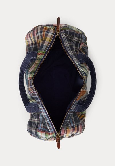 Ανοιχτό μπεζ τσαντάκι πλάτης με μπλε λαβές και καφέ δερμάτινη λαβή φερμουάρ, που δείχνει το άδειο σκούρο εσωτερικό σε λευκό φόντο.