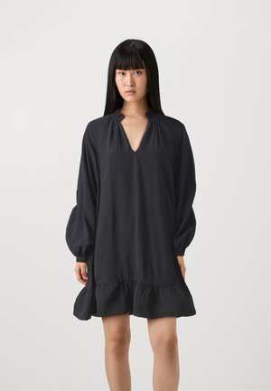 Zwarte, knielange jurk met een V-hals en eenGathered neckline. Beschikt over lange, opgeblazen mouwen en een gerimpelde zoom. Glad, lichtgewicht materiaal.
