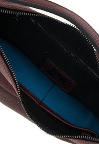 Borsa a mano in pelle bordeaux con chiusura a zip; presenta un interno nero e una fodera blu brillante. Include una tasca laterale con dettagli in zip.
