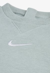 Ανοιχτοπράσινο πουλόβερ με ριμπ σχέδιο στη λαιμόκοψη και λεπτομέρεια στον ώμο. Διαθέτει λευκό κεντημένο λογότυπο Nike στο στήθος. Μαλακό, υφασμάτινο ύφασμα με υφή.
