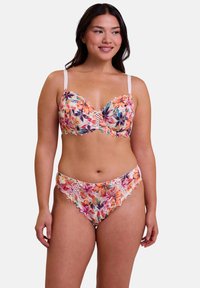 Ensemble de soutien-gorge en dentelle florale et de culotte assortie, mettant en avant des couleurs vives, des bords festonnés et des détails croisés au centre, fabriqué en tissu léger.