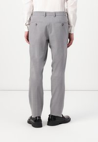 Gray tailored trousers with a textured finish, featuring two back pockets with button closures and a straight leg design. Worn with black shoes.