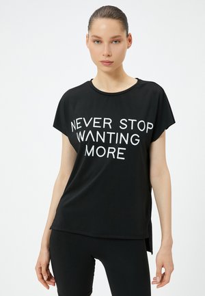 Sort, kortærmet t-shirt med rund hals og fed hvid tekst med teksten "NEVER STOP WANTING MORE." Glat stof med en afslappet pasform.