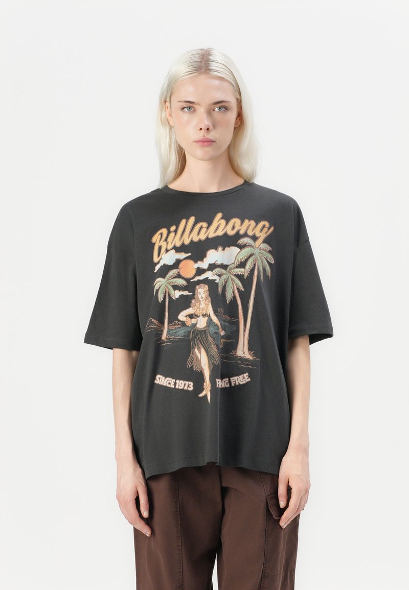 Black oversized t-shirt featuring a vintage-style graphic with a hula dancer, palm trees, and the text "Billabong Since 1973" in light colors.
