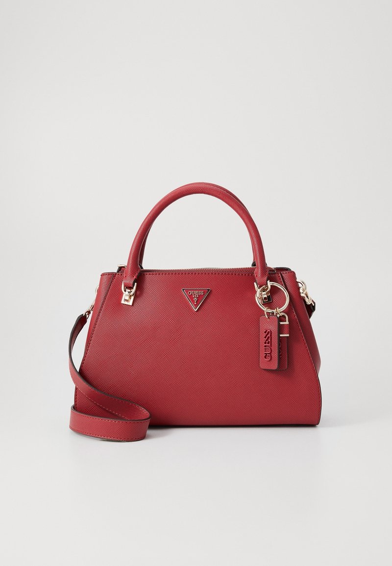 Sac à main rouge texturé avec deux poignées, une bandoulière amovible, une quincaillerie dorée et une étiquette logo Guess à l'avant.