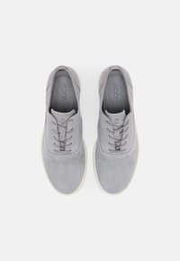 Scarpe in suede grigio con lacci, punta tondeggiante e suola in gomma bianca, viste dall'alto.