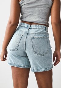 Ljust tvättade denimshorts med en uppvikd kant, med två bakfickor och hög midja. Materialet har en klassisk jeansstruktur.