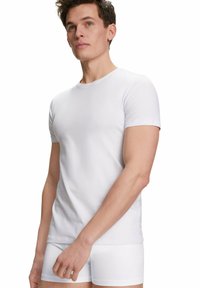 Maglietta bianca a maniche corte realizzata in morbido tessuto di cotone, con scollatura a girocollo e design aderente, abbinata a slip boxer bianchi.