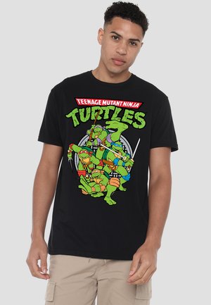 Black cotton t-shirt featuring a colorful graphic of four turtles with weapons and the text "TEENAGE MUTANT NINJA TURTLES" in bold.