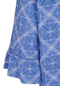 Blauwe stof met een geometrisch patroon in het wit, met complexe stiksels en een gerimpelde zoomdetail.