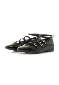 Ballerine in vernice nera con punta appuntita, multiple cinghie sottili sulla parte frontale e fibbie argentate sulle cinghie alla caviglia.