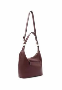 Sac à épaule en cuir bourgogne profond avec une finition texturée, une seule bandoulière et une poche frontale zippée. Présente des accents en matériel ton or.