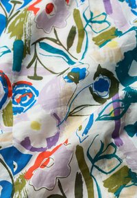 Floral fabric with colorful watercolor designs in blue, green, red, and purple on a white background, featuring abstract leaf and flower shapes.