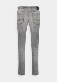 Grå denimjeans med rak bendesign, utrustad med två bakfickor med sned sydda detaljer och en läderpatch i midjan.