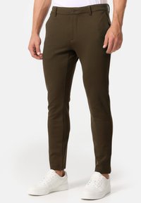 Pantaloni slim-fit verde oliva realizzati in tessuto elasticizzato, con chiusura frontale a bottone, tasche laterali e dettagli delle cuciture sottili.