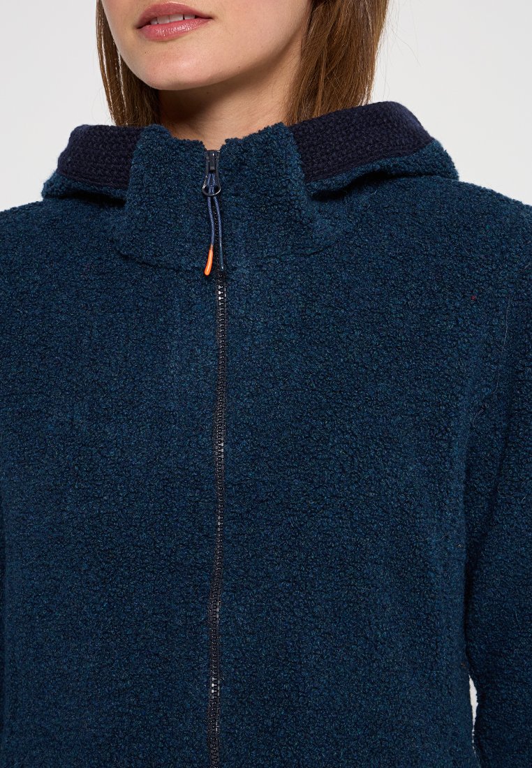 Marineblaue Fleece-Jacke mit strukturierter Oberfläche, hohem Kragen, Reißverschluss und kontrastierender dunkelblauer Kapuzenbesatz. Sichtbarer oranger Reißverschluss-Zug.