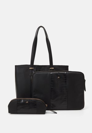 Set de sacs noirs comprenant un grand tote, une housse pour ordinateur portable et une petite pochette. Textures lisses et effet crocodile avec des accents dorés.