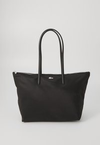 Black nylon tote bag with two black leather handles, zip closure, and a silver logo on the front. Smooth texture, spacious design.