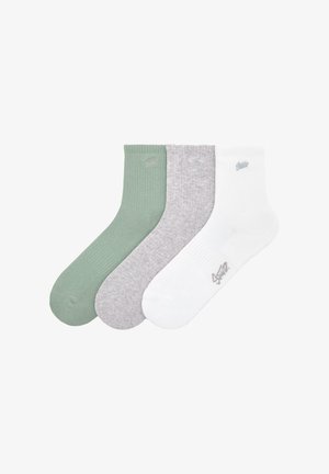 Kolme paria nilkkasukkia: yksi vihreä, yksi harmaa ja yksi valkoinen. Jokaisessa sukassa on ribbikuvio ja pieni logo yläosassa.