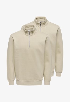 Two beige quarter-zip sweatshirts with stand collars, ribbed cuffs, and hem, layered against a white background.