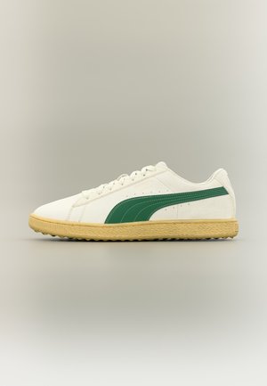 Hvit og beige lavsko med grønn sidestripe og teksturert såle, vist fra siden på en nøytral bakgrunn.