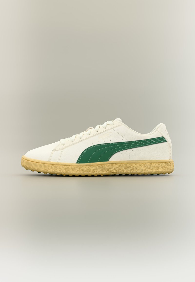 Λευκό και μπεζ αθλητικό παπούτσι χαμηλού προφίλ με πράσινη πλευρική ρίγα και υφή στη σόλα, εμφανίζεται από το πλάι σε ουδέτερο φόντο.