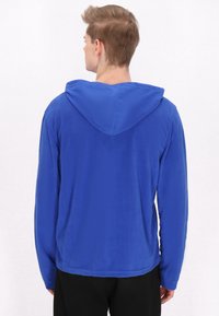 Felpa con cappuccio realizzata in morbido pile blu, con maniche lunghe, vestibilità rilassata e design semplice, caratterizzata da un orlo rotondo.