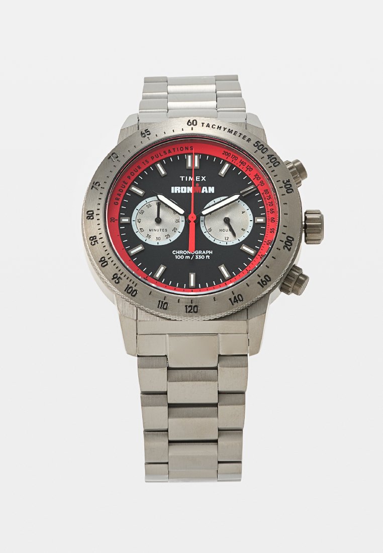 Reloj cronógrafo Timex Ironman con correa de acero inoxidable, esfera negra, dos subesferas plateadas, anillo rojo de pulsaciones y bisel taquimétrico.