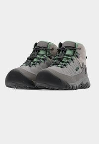 Γκρι ορειβατικά μποτάκια με πράσινες λεπτομέρειες, με ανάγλυφη επάνω επιφάνεια, ανθεκτική λαστιχένια σόλα και σύστημα κορδονιών τύπου bungee για σταθερή εφαρμογή.