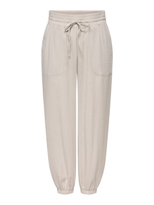 Pantalon de jogging beige avec taille élastique, cordon de serrage à l'avant, deux poches plaquées à l'avant et poignets élastiques aux chevilles.