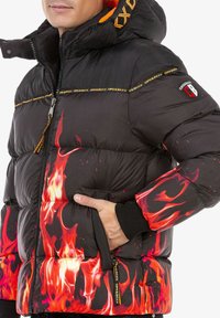 Schwarze Pufferjacke mit rotem Flammenmuster an den Ärmeln. Verfügt über einen hohen Kragen, einen Frontreißverschluss, Logopatches und elastische Bündchen.