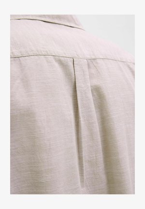 Lys beige skjorte med en subtil tekstur, der har en rygfold og en klassisk krave, lavet af blødt, åndbart stof.