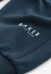 Marineblauwe katoenen joggers met geribde boorden; voorzien van het witte "BAKER by TED BAKER" logo in moderne lettertype, met een soepele textuur.