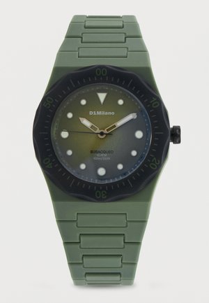 Zöld búváróra fekete forgó lünettával, világító mutatókkal, széles mutatókkal és a számlapon "SUBACQUEO 10 ATM 100m/330ft" felirattal.