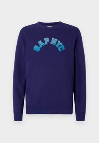 Navy sweatshirt made of cotton, featuring the text "GAP NYC" in light blue embroidered arch style on the front. Classic crew neckline.