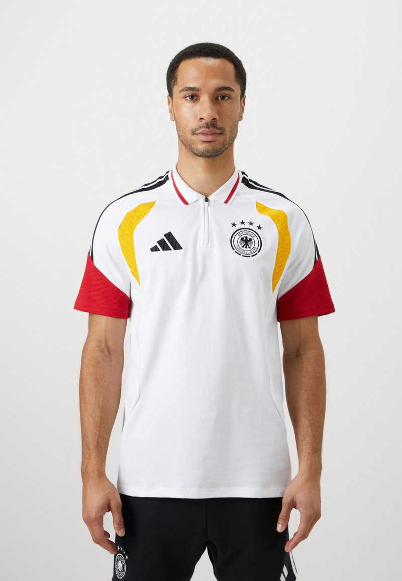 Camisola polo branca com detalhes em vermelho e amarelo, colarinho de dois botões, três estrelas acima de um logótipo circular, riscas pretas nos ombros.