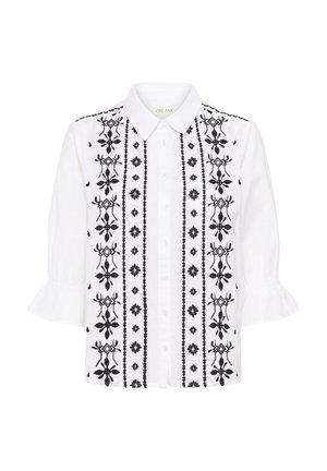 Blouse blanche à boutons avec une broderie florale verticale noire, un col pointu et des manches trois-quarts à volants.