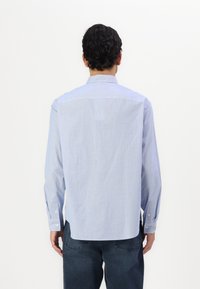Camisa de manga larga a rayas azul claro, con corte recto, puños con botones y cuello clásico. Tejido de algodón suave, vista trasera mostrada.