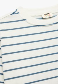 Sweter z bawełny w pionowe białe i niebieskie paski, z okrągłym dekoltem i prążkowanymi wykończeniami. Ma poziome paski i wszytą metkę.