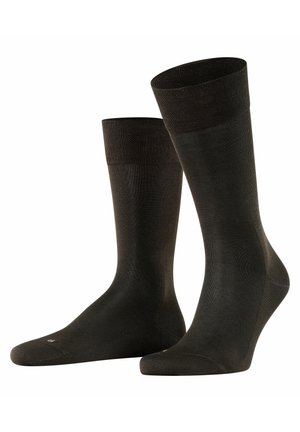 Calcetines de tripulación negros con un puño acanalado, textura suave y puntera reforzada. Están hechos de un tejido elástico para mayor comodidad y durabilidad.