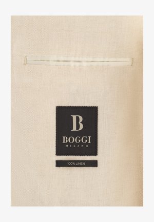 Tissu en lin beige avec détail de poche passepoilée, étiquette noire indiquant « B Boggi Milano » et petite étiquette mentionnant « 100 % lin ».