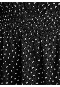 Melna auduma ar savilkta, smockēta jostasvietu, kuram ir baltu punktiņu un apļu raksts. Mīksta tekstūra ar dažādām punktiņu izmēriem.