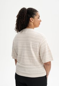 Lichtbeige korte mouwen gebreide trui met gestructureerde horizontale strepen, ronde halslijn, geribde boorden en zoom; relaxte pasvorm.