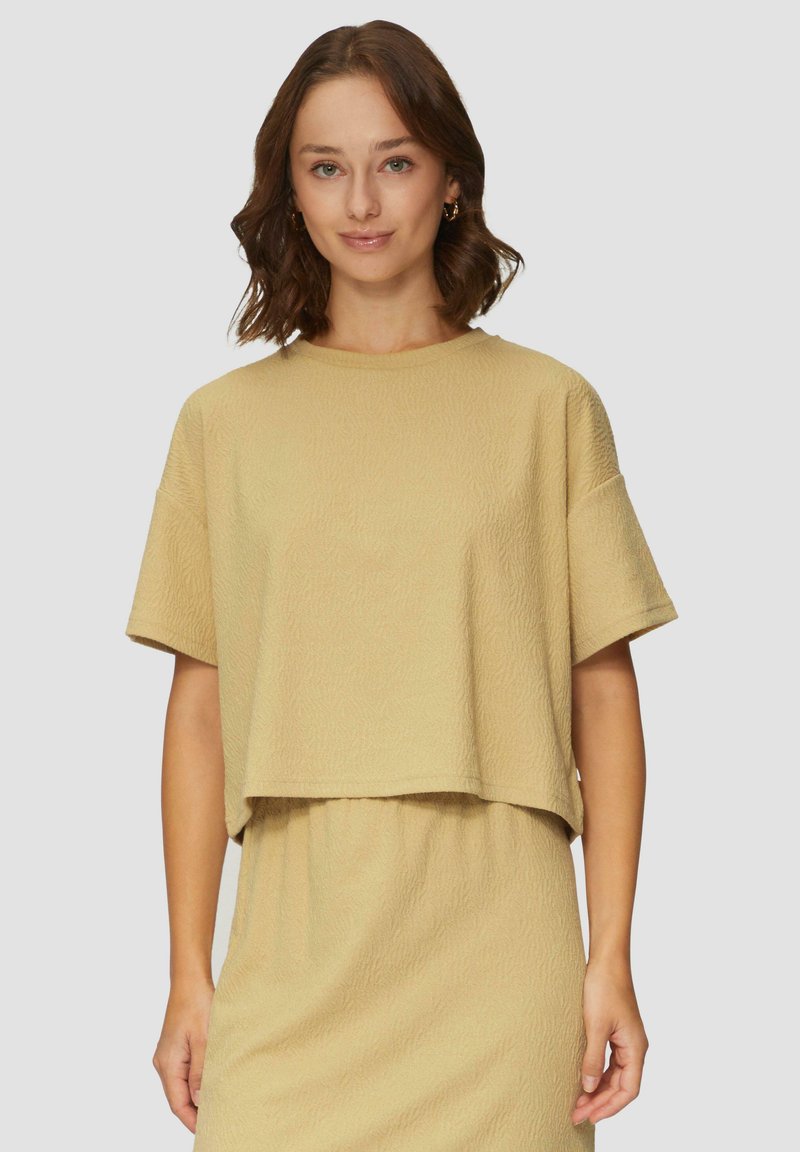 Lichtbeige textuur geperforeerde cropped top met korte mouwen, ronde crew-halslijn, met een subtiel reliëfpatroon.