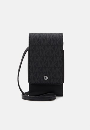 Petit sac téléphonique noir porté croisé avec motif monogramme MK, rabat avec fermeture pression, et sangle fine réglable.