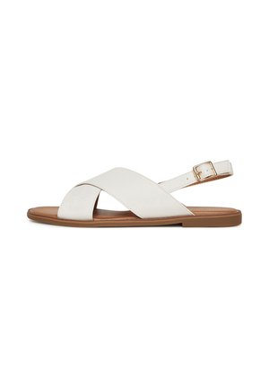 White leather sandals with crossed straps and a buckle closure. Flat brown sole, smooth texture, minimalistic design.