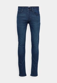 Jeans de corte ajustado en azul oscuro. Confeccionados en una mezcla de algodón, cuentan con cinco bolsillos, cierre de botón y sutiles detalles de desgastado a lo largo de las piernas.